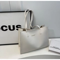 Detail of white minimalist tote bag featuring gold branding and elegant shoulder straps - Off White