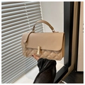 Detalle de bolso acolchado beige con cierre giratorio dorado y textura bordada - Caqui