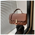Close-up of brown quilted faux leather bag with gold buckle and chain strap detail - Brown