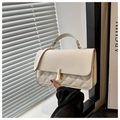 Detalle macro del bolso acolchado blanco crema con elegante cadena dorada y cierre - Blanco