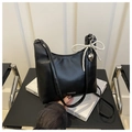 Detailed close-up of the black leather shoulder bag with a pearl bow and heart charm - Black