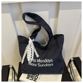 Détail du sac cabas en jean bleu avec slogan Less Mondays et nœud en dentelle blanche - Bleu clair