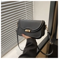 Detail of black leather flap bag featuring golden cylindrical metal buckle and stitching - Black