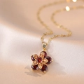 Elegante ketting met roterende bloemhanger en rode stenen op goudkleurige zijde - Roterende Rode Bloem (X1590)