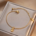 Elegantes goldenes Titanstahl-Armband mit Kürbis-Anhänger auf edlem Seidendisplay - Kürbis Glücksanhänger Stil (TS060)