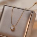 Minimalist square shell pendant on gold titanium necklace displayed on a jewelry box - Shell Necklace (T0158)