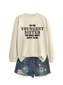 Detail of cream sweatshirt with 'I'M THE YOUNGEST SISTER' text and blue denim shorts - Sand (Black Font)