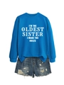 Flat lay of blue sweatshirt and distressed denim shorts with I'M THE OLDEST SISTER text - Lake Blue (White Font)