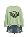 Detail of light green sweatshirt with I'm the oldest sister slogan and ripped denim shorts - Olive Green (Black Font)