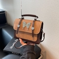 Bolso bandolera vintage bicolor con textura mate y adorno de mariposa plateada - Caqui con Café