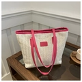 Detail of straw woven tote bag featuring bright magenta leather straps and trim texture - Rose Pink