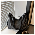 Detail view of black textured leather bag with zipper and logo patch on casual shoulder strap - Black Without Pendant