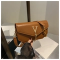 Dettaglio di una borsa a tracolla marrone con logo V dorato e nappine metalliche - Marrone