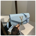 Dettaglio borsa azzurra con logo V dorato, nappa metallica e catena in acrilico - Blu