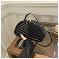 Detail of black semi-circle saddle bag featuring V-shaped quilting and gold-tone hardware - Black