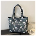 Close-up of a large tote bag with skull and floral patterns in gothic punk style - Green
