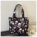 Macro shot of large black tote bag featuring gothic skull and purple flower pattern print - Fuschia