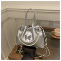 Détail du sac seau argenté avec gaufrage papillon et chaîne ornée de perles - Argent