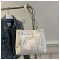 Detalle de bordado de rayas coloridas y asa de cadena dorada en bolso blanco - Blanco