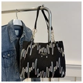 Detail of black textured tote bag with colorful wave embroidery and chain handle - Black