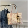 Detail of a beige tote bag with pink graffiti lettering and a cute knit bear pendant - With Pendant / Pink