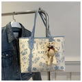 Detail of a retro tote bag with blue graffiti print and a cute knit bear charm - With Pendant / Blue