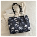 Detail of skull print tote bag with silver chain strap and fashion label on fabric - Blue