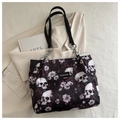 Detail of fashion tote bag featuring skull floral print and silver chain strap details - Fuschia