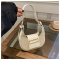 Woven crescent hobo bag with white leather trim and gold buckle on a wooden table - White