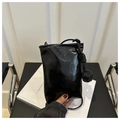 Dettaglio di mini borsa minimalista in pelle verniciata nera con tracolla a nodo - Nero