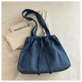 Detail of blue denim tote bag with drawstring closure and functional front pockets - Denim Blue