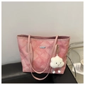 Gros plan du cabas matelassé rose avec un pendentif nuage en peluche sur un banc en cuir - Avec Pendentif Nuage / Rose