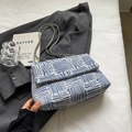 Borsa a tracolla intrecciata bianca e blu con catena e patta su blazer scuro - Blu