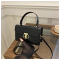 Detail of black crocodile texture handbag with elegant gold metal twist lock and top handle - Black