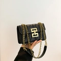 Chic black quilted crossbody bag with golden chain strap and geometric rotary lock - Black