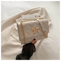 Dettaglio della borsa a tracolla trapuntata beige con chiusura a fiocco dorato e catena - Bianco Sporco