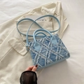 Light blue denim handbag featuring distressed frayed edges and premium gold hardware - Blue
