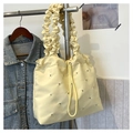 Detail of light yellow nylon bucket bag with ruffled straps and drawstring closure - Yellow