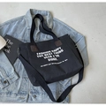Schwarze Canvas-Tragetasche mit weißer Typografie und Lederdetails auf Denim-Stoff - Schwarz