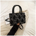 Borsa a mano in tweed nero con frange a rombi e manico rotondo tenuta in mano - Nero