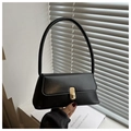 Detail of minimalist black baguette bag with gold twist lock and smooth leather texture - Black