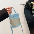 Bolso tipo cubo cilíndrico azul con bordado de mariposa dorada y asa superior fija - Azul
