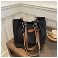 Detalle del bolso tote de lona negra con correas de cuero marrón y cadena plateada - Negro