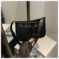 Close-up of black PU leather shoulder bag featuring gold eyelets and drawstring detail - Black
