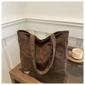 Close-up of brown corduroy tote bag with red strawberry embroidery on a coffee table - Brown