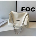 Details der cremefarbenen Ledertasche mit Metallleiste und geflochtenem Kettenriemen - Weiß