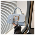 Sky blue leather handbag with gold buckle and matching mini pouch in natural light - Blue