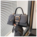 Detail of black litchi leather handbag featuring a large gold U-buckle and mini coin purse - Black