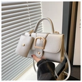Detail of silver litchi textured leather handbag with gold buckle and mini pouch accessory - Silver