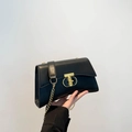 Chic black textured leather shoulder bag with a gold chain strap and stylish lock - Black